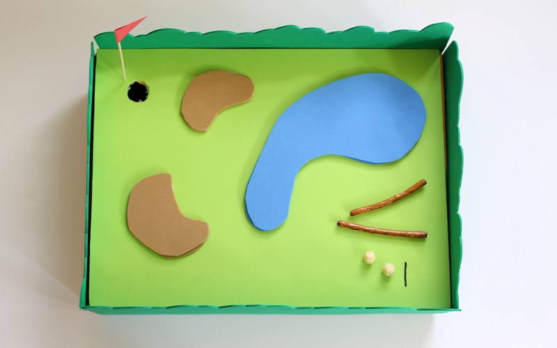 tabletop mini golf hole made out of cereal box and craft supplies
