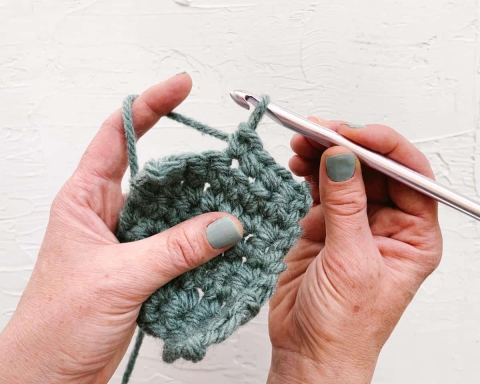 2 hands, crochet hook and yarn
