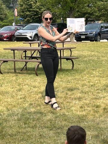 Librarian reading a book to a group outside