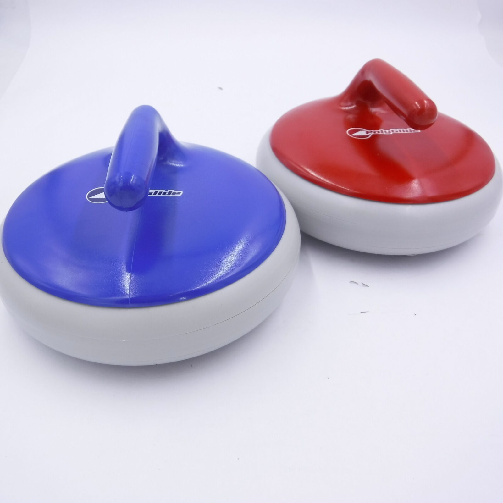 One blue and one red curling stone each with a handle for delivery of the stone