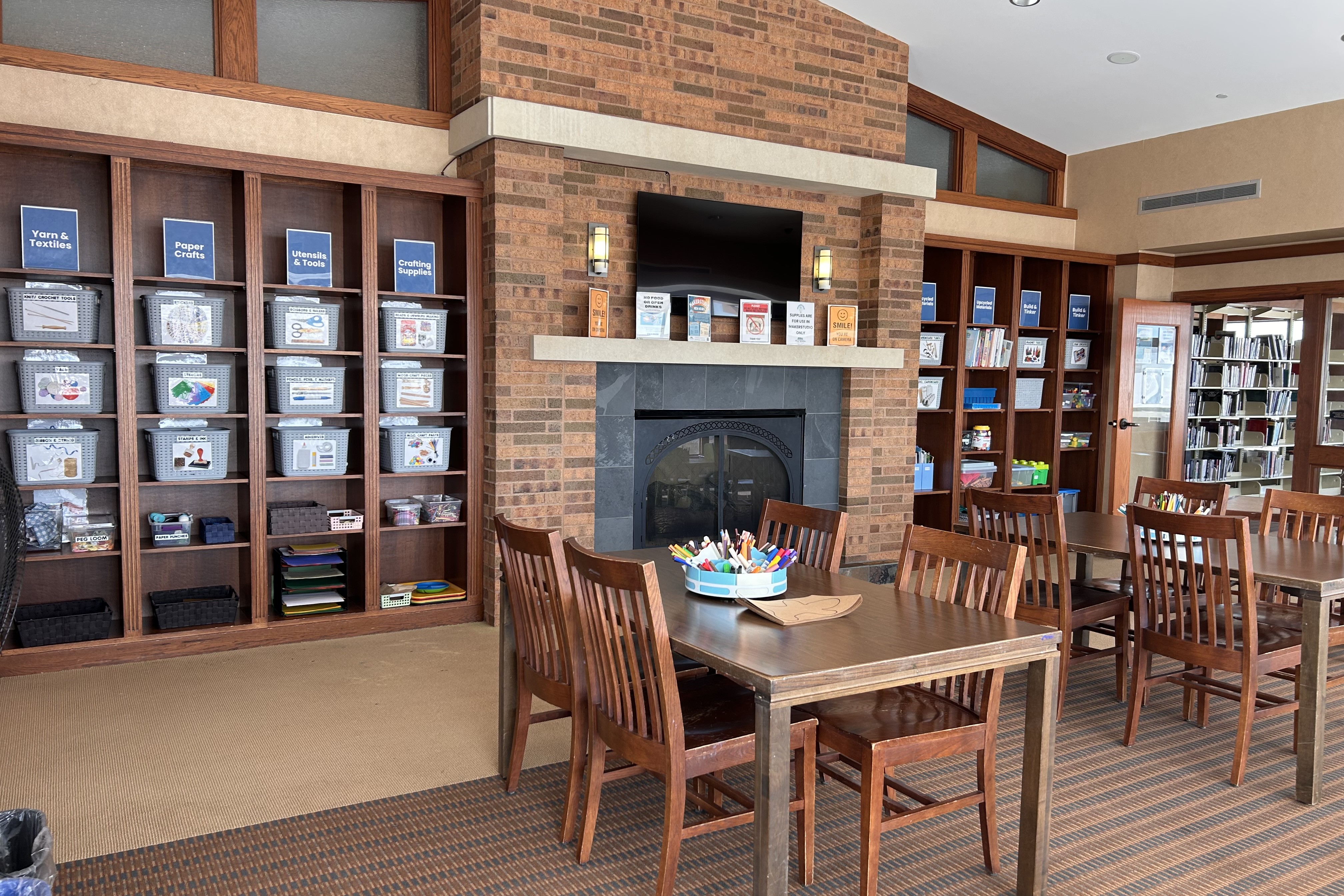 image of makerstudio room with shelves of craft supplies, tables and chairs