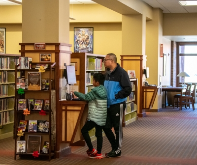 Two people using the catalog computer in the library