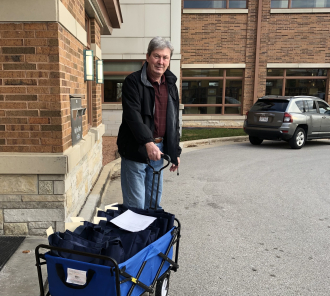 Man with wagon full of materials for home delivery