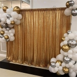 shimmery gold backdrop used for pictures surrounded by white, silver and gold balloons