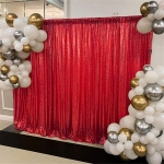shimmery red backdrop used for pictures surrounded by white, silver and gold balloons