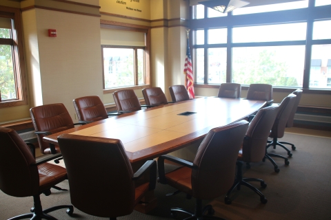Board room space with large table surrounded by chairs