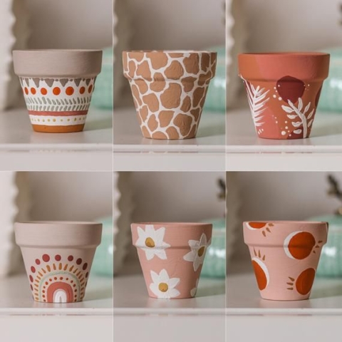 six different mini terracotta pots painted in different ways