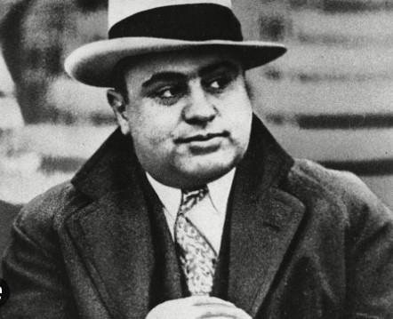 gangster, al capone, man dressed in hat and suit and coat looking off to his side troubling