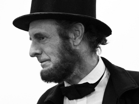 Photo of Abraham Lincoln in his suit, bowtie and hat, portrayed by historian Kevin Wood 