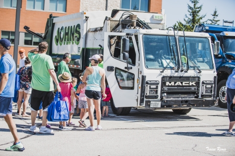 People visiting with the garbage truck 