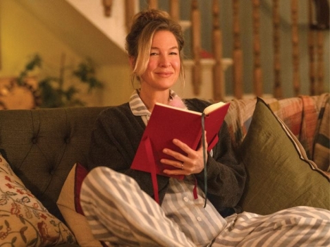image of woman sitting on couch holding an open book