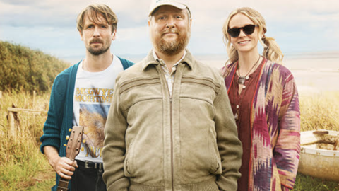 image of 3 people standing on an island