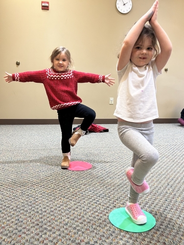Two children doing tree yoga pose