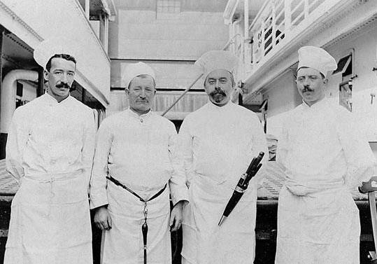 4 men in white chef uniforms and hats, historic picture from titanic kitchen