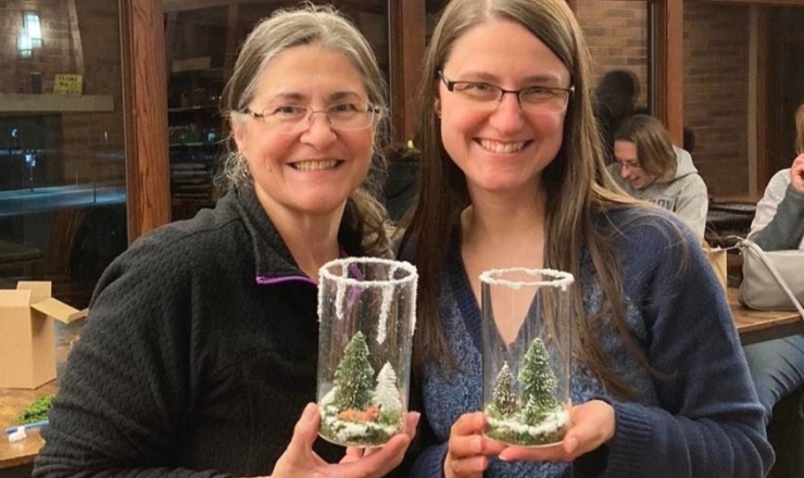 Two people holding their craft creations at a MakerStudio craft night.