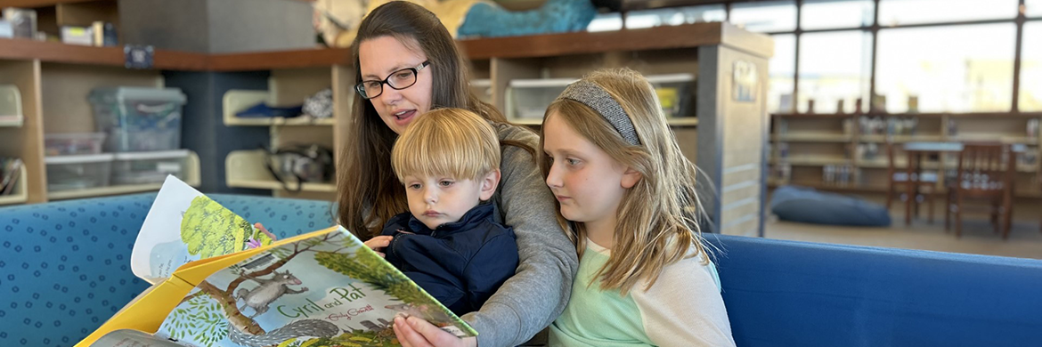 Mom, son and daughter reading in the library